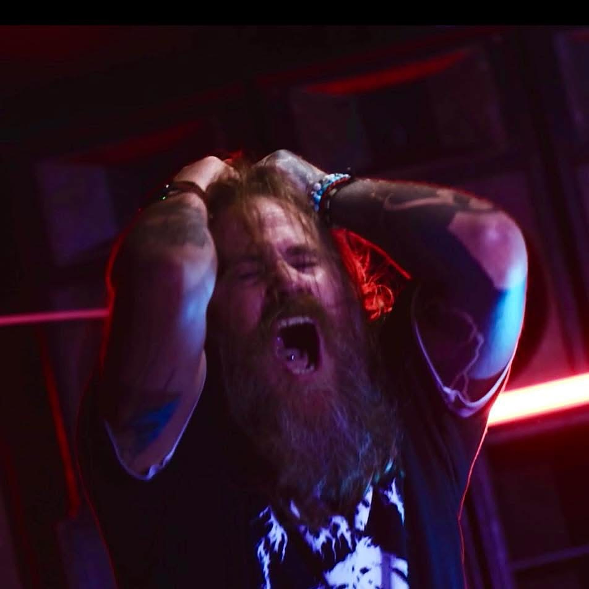 Shortie screaming into the mic on stage under red and blue stage lights, Captain Khaos Records